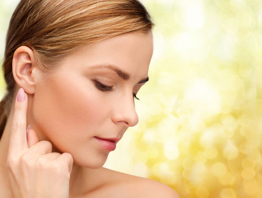 Young woman pointing at her ear.